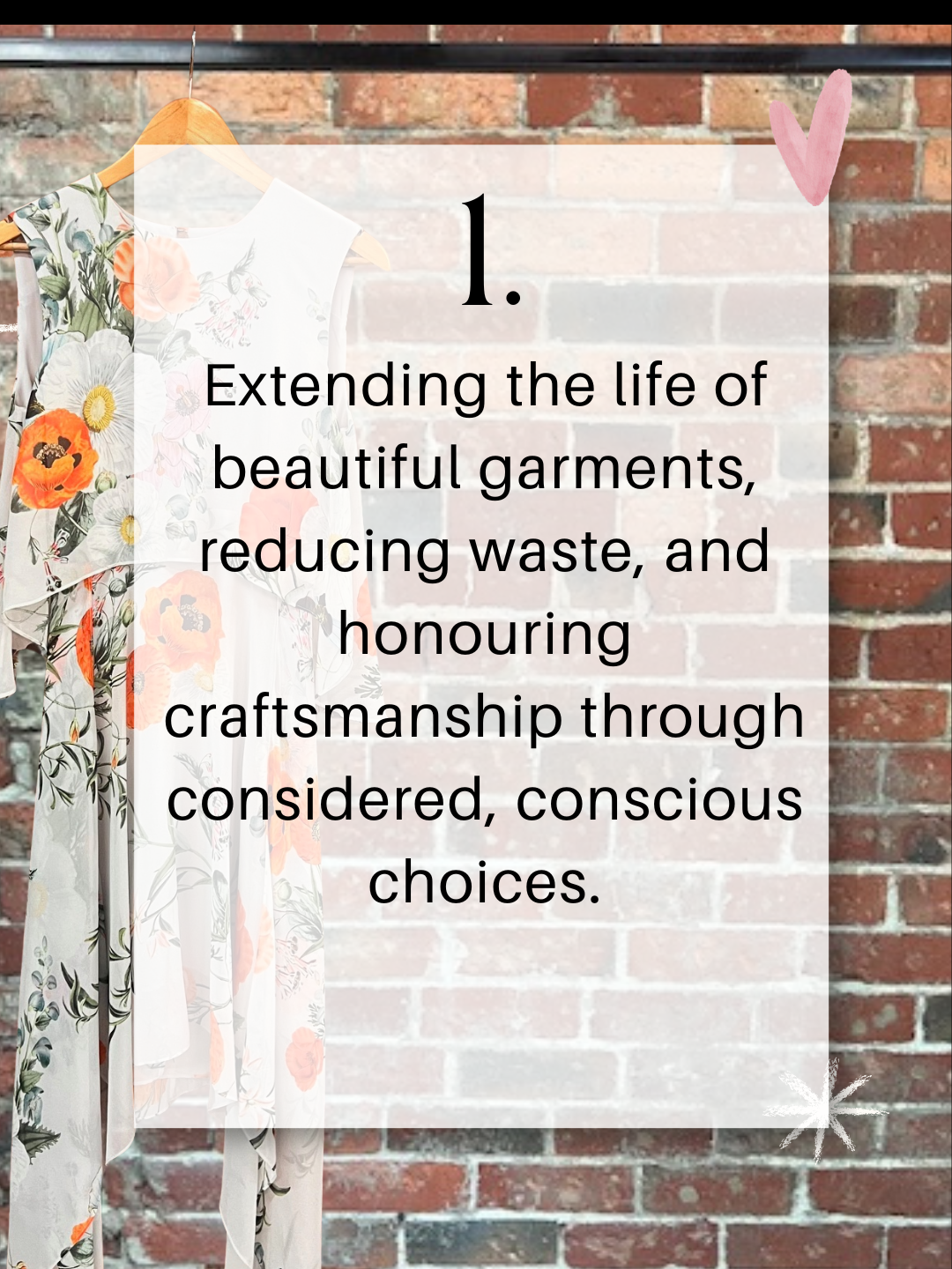 A floral dress hanging against a red-brick wall